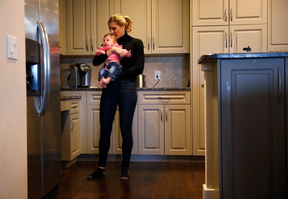Jenny Boucek comforts her 4-month-old daughter, Rylie, as she walks around her home in...