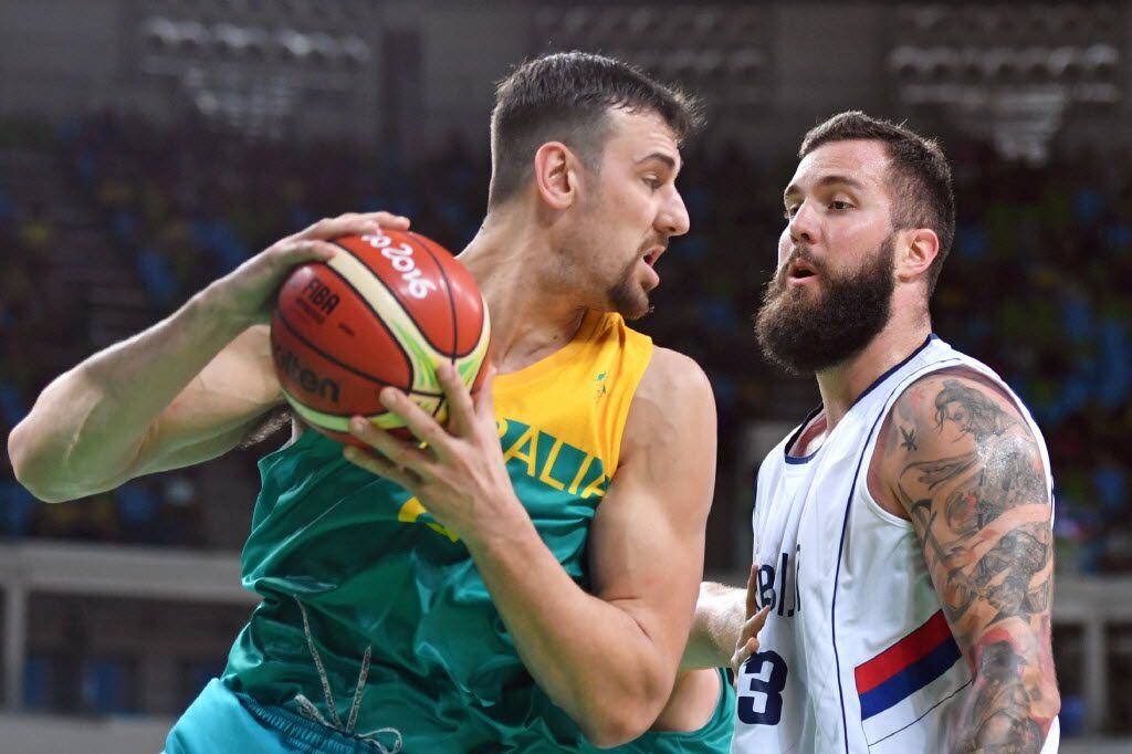 Australia's centre Andrew Bogut (L) holds on to the ball next to Serbia's centre Miroslav...