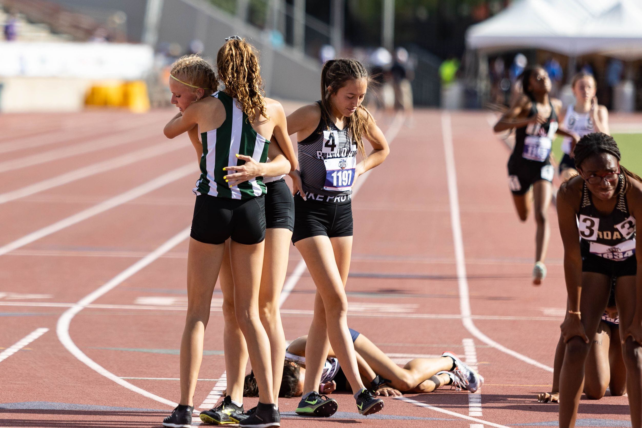 Kailey Littlefield of Lucas Lovejoy, left, hugs a competitor after winning the girls’ 800m...