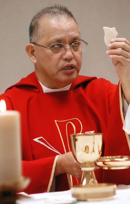 Rev. Edmundo Paredes prepares for communion during a mass in June, 2008 at St. Cecilia...