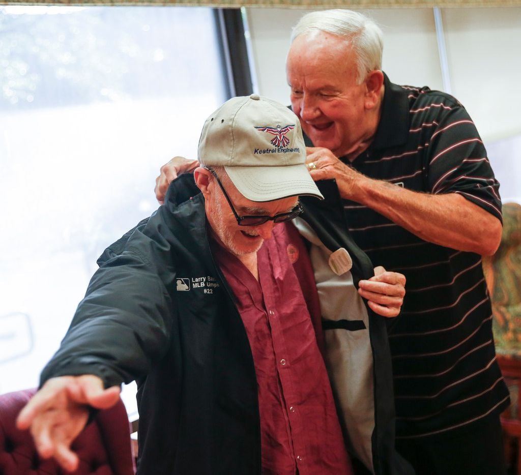 Retired major league umpire Larry Barnett, who has visited hospitalized veterans since 1977, presents a jacket to Russell Moore, a Navy veteran, during a visit to the VA North Texas Health Care System on Thursday, Aug. 8, in Dallas. 