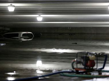 Water is pumped out of a flooded lower level parking garage A at Dallas Love Field under...