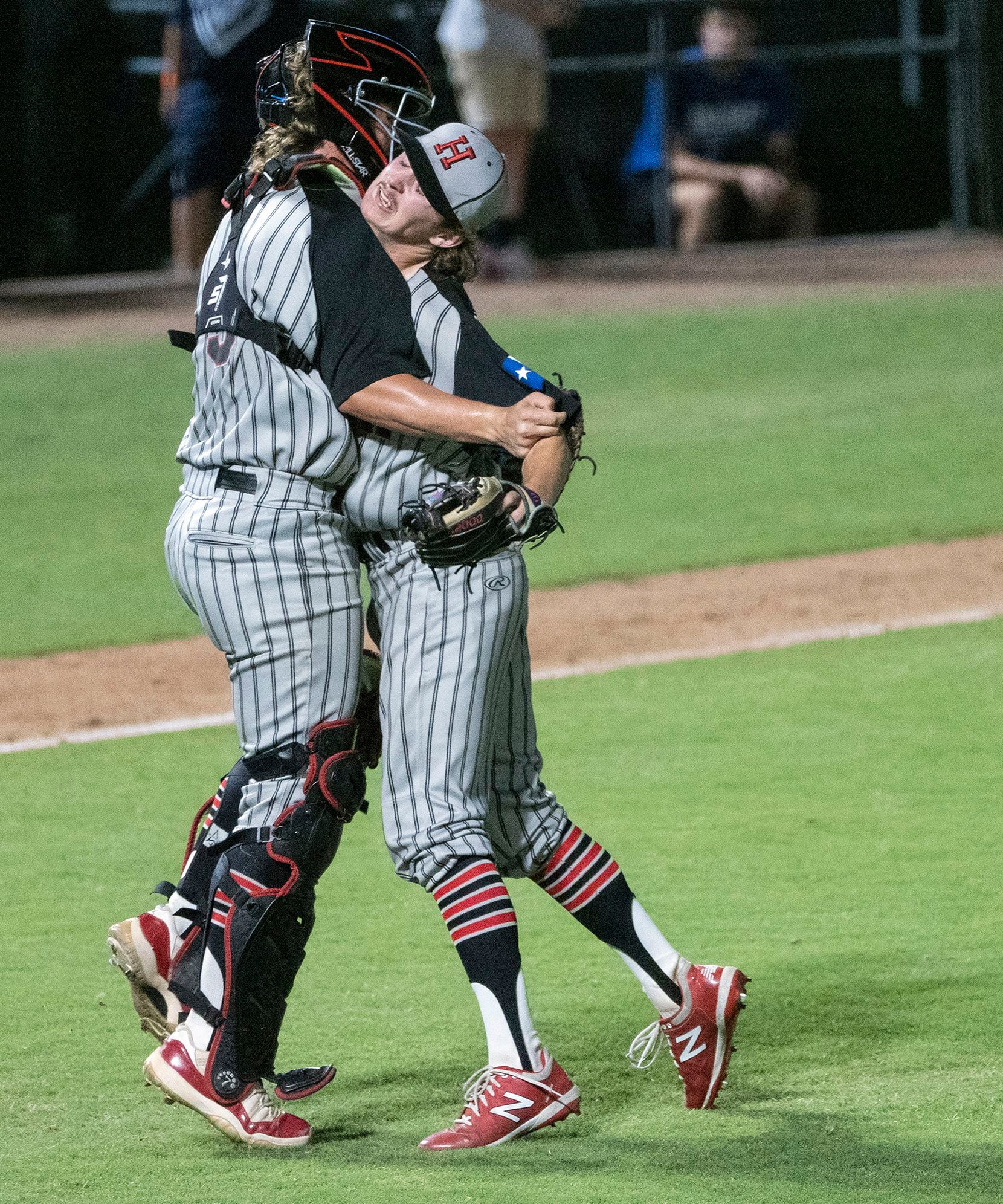 Rockwell-Heath pitcher, Baylor Baumann, (1), is hugged by catcher, Kevin Bazzell, (9), after...