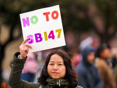 Liu Yang holds a sign in opposition to Texas Senate Bill 147 during a rally on Sunday, Jan....
