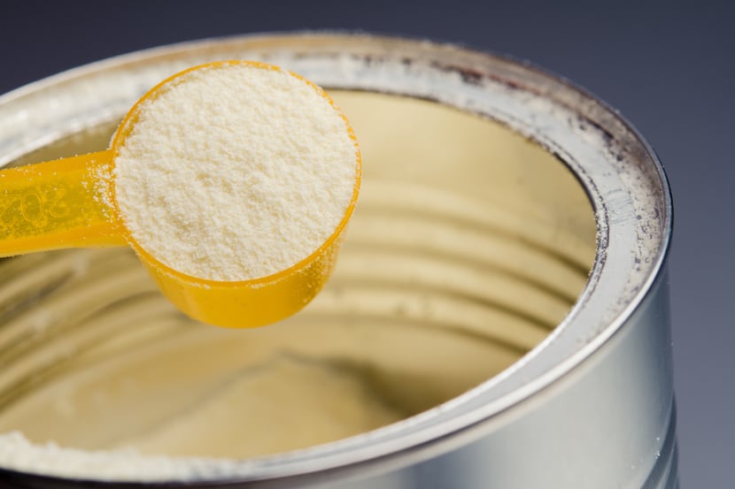 A close-up of baby formula powder in a can.