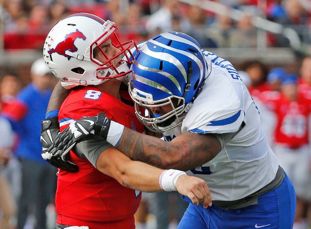 SMU quarterback Ben Hicks (8) is hit by Memphis safety Thomas Pickens (40) after he released...