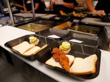 The kitchen makes and assembles orders during the opening of Dave’s Hot Chicken in Plano on Friday, October 29, 2021.