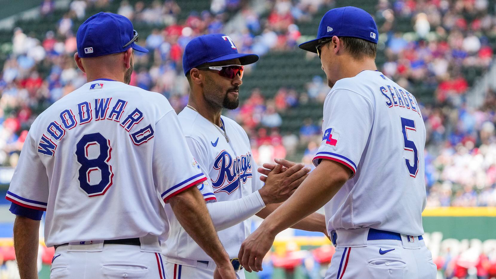 Texas Rangers shortstop Corey Seager shakes hands with second baseman Marcus Semien and...