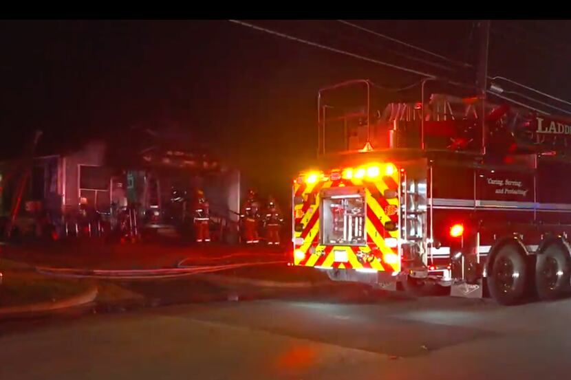 Bomberos trabajando para extinguir un incendio en una casa en South Dallas.