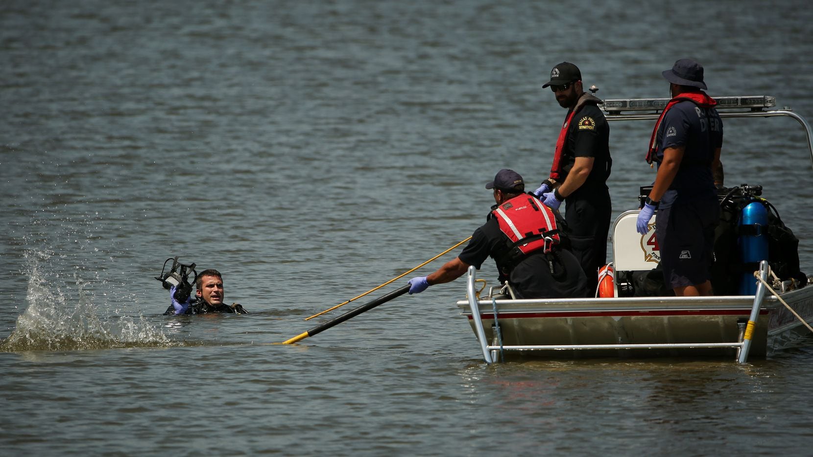 A Dallas Fire-Rescue crew and a Dallas police diver search for a man after he entered the...
