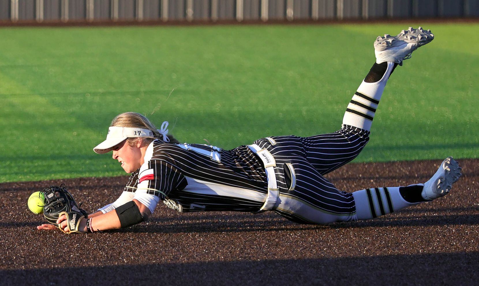 Royce City shortstop Jenna Joyce tries to come up with a groundball against Prosper Rock...