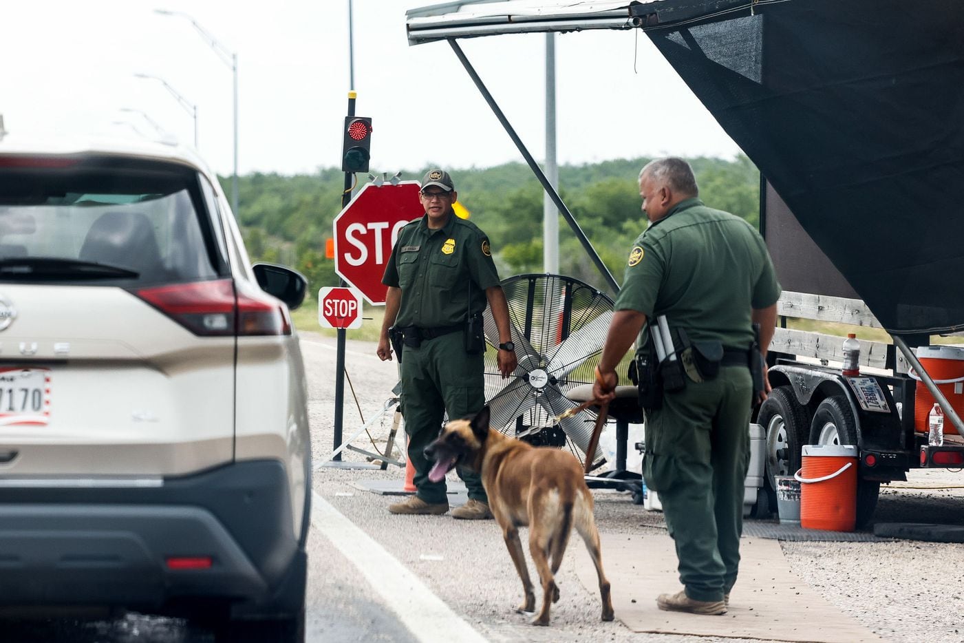 Border Patrol officers inspect a line of cars in on US-90 in Uvalde, Texas on Tuesday, May...