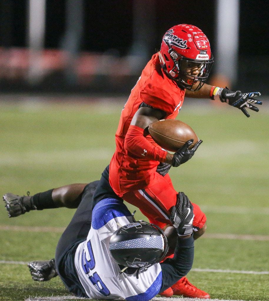 Cedar Hill wide receiver Quin Bright (1) carries the ball as he is defended by Mansfield...