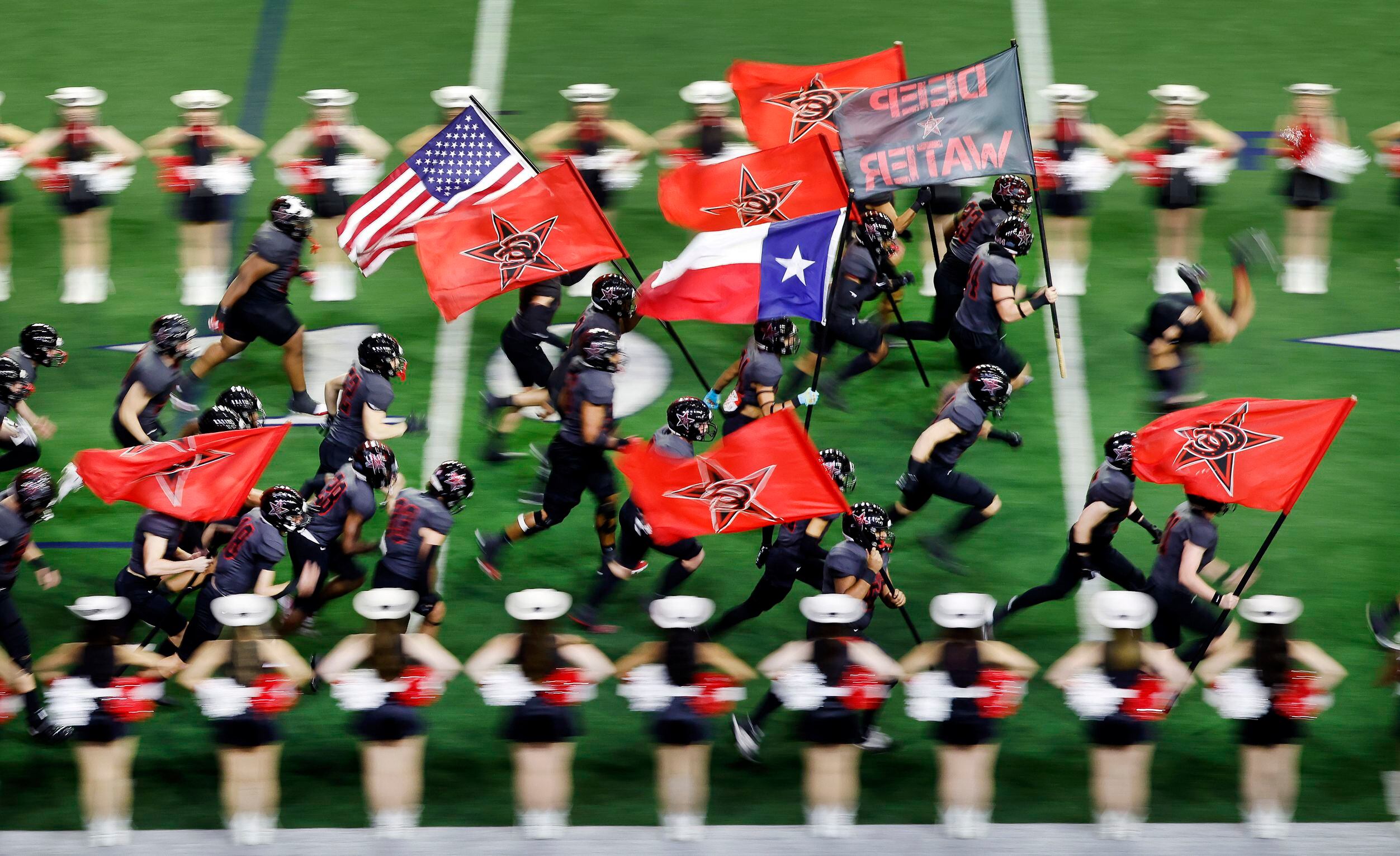 The Coppell Cowboys football team races onto the field during team introductions before...