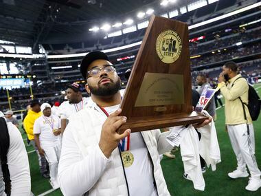 South Oak Cliff assistant coach Domenic Spencer raises the championship trophy after the...
