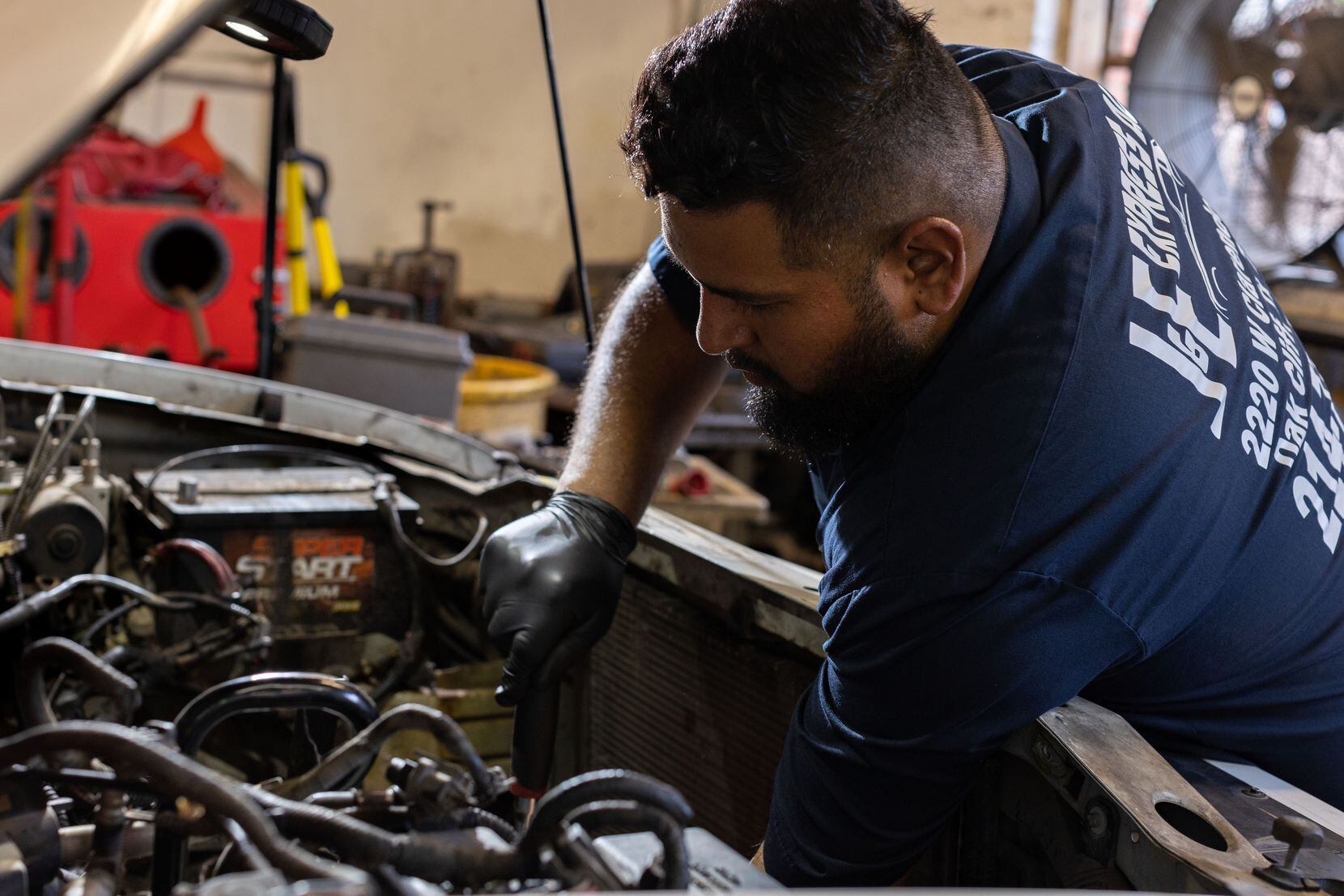 Gerardo Figueroa trabaja en un auto en su taller, J&E Express Auto Service, en Oak Cliff el...