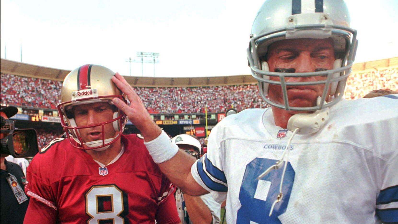 Dallas Cowboys quarterback Troy Aikman, right, pats San Francisco 49ers quarterback Steve...