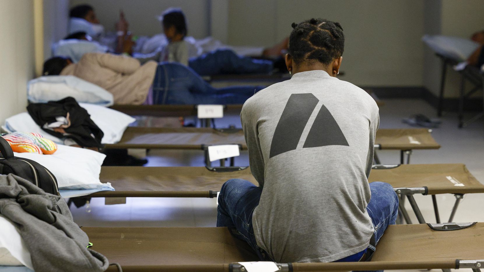 Migrants rest on cots in a room at Oak Lawn United Methodist Church in Dallas, Wednesday....