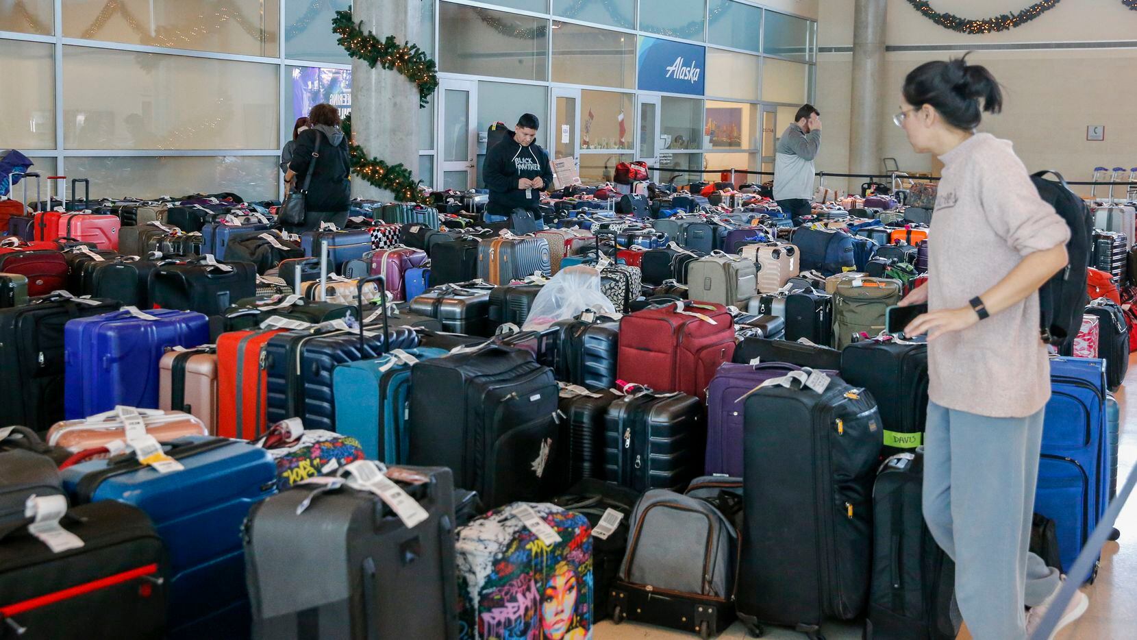 Southwest Airlines employees and passengers search through hundreds of unclaimed bags at...