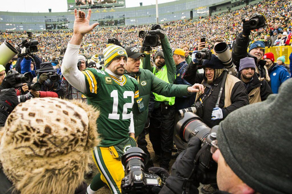 Green Bay Packers quarterback Aaron Rodgers (12) waves to the crowd as he leaves the field...