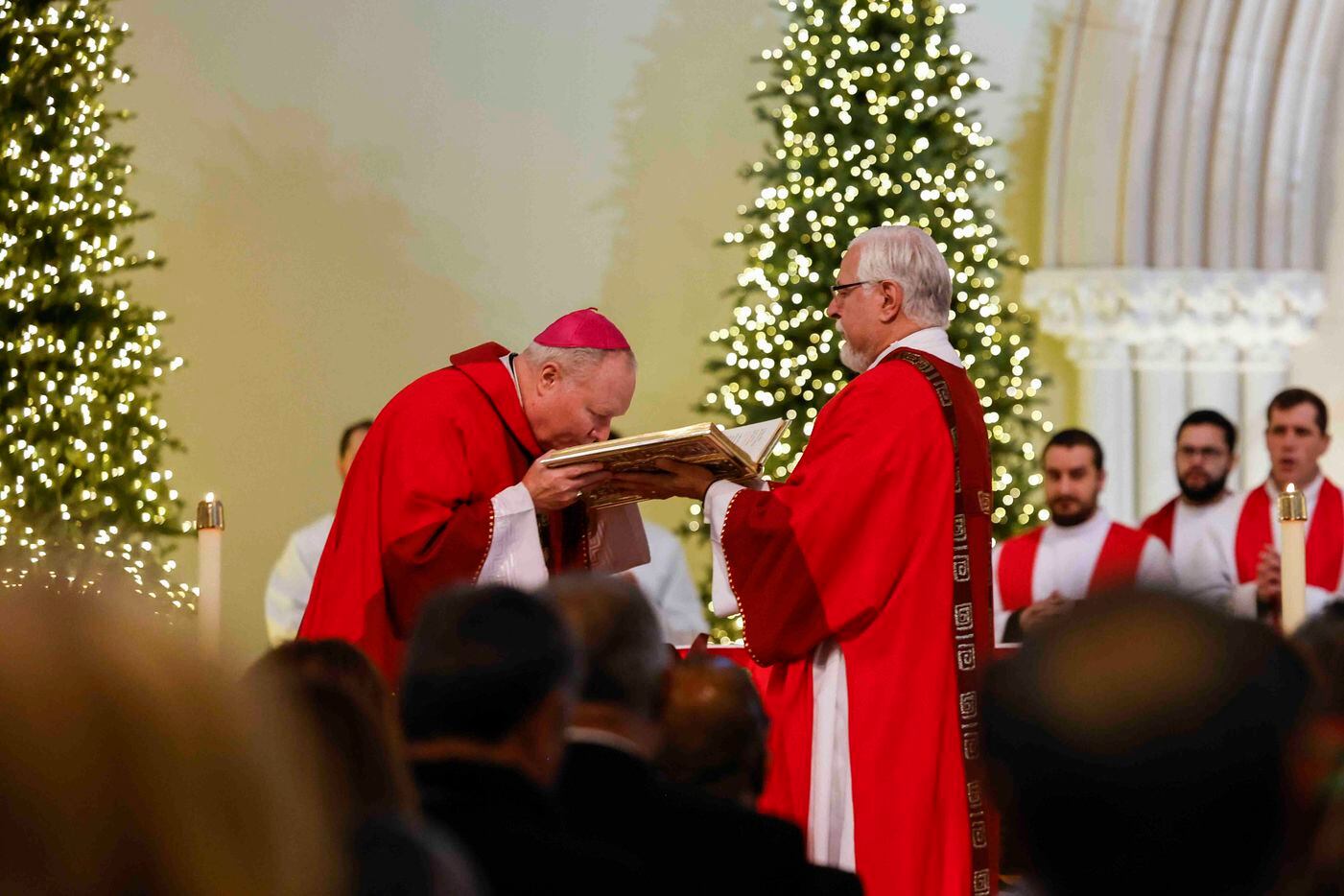 Bishop Edward J. Burns venerates the Lectionary during a memorial mass for late Pope...