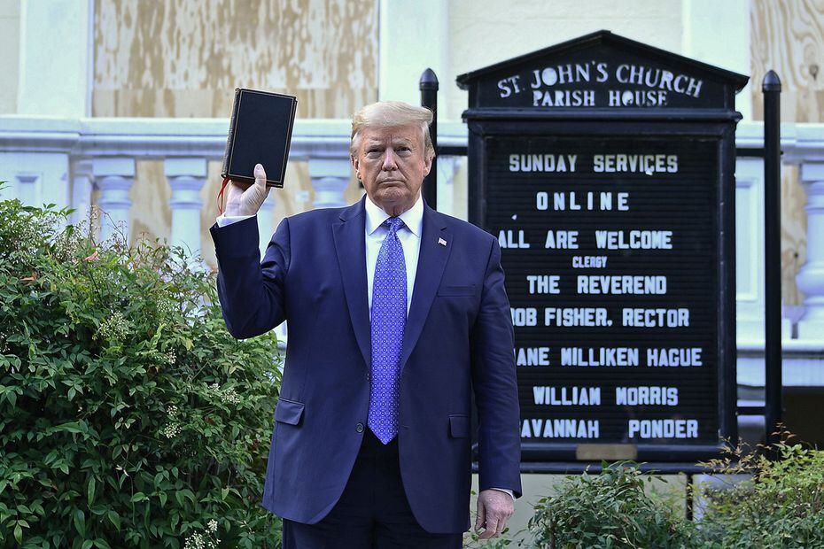 President Donald Trump holds up a Bible outside of St John's Episcopal church across...