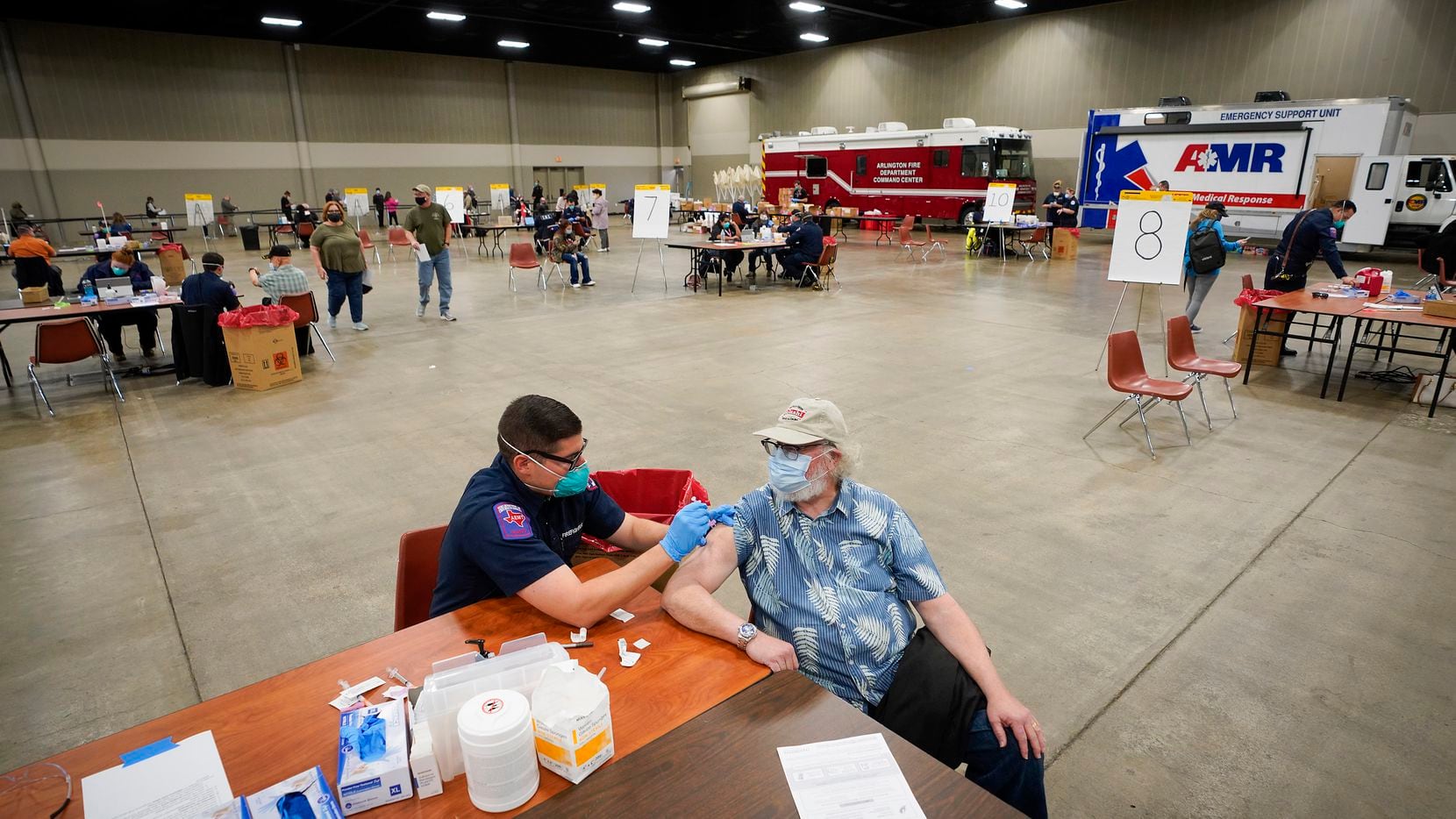 Joe McKay receives the Moderna COVID-19 vaccine from Arlington firefighter Derek O’Neill at the Esports Stadium Arlington & Expo Center on Tuesday, Jan. 5, 2021, in Arlington. The Tarrant County Public Health (TCHP) vaccination program is being implemented by the Arlington Fire Department as part of the city’s mass vaccination effort.