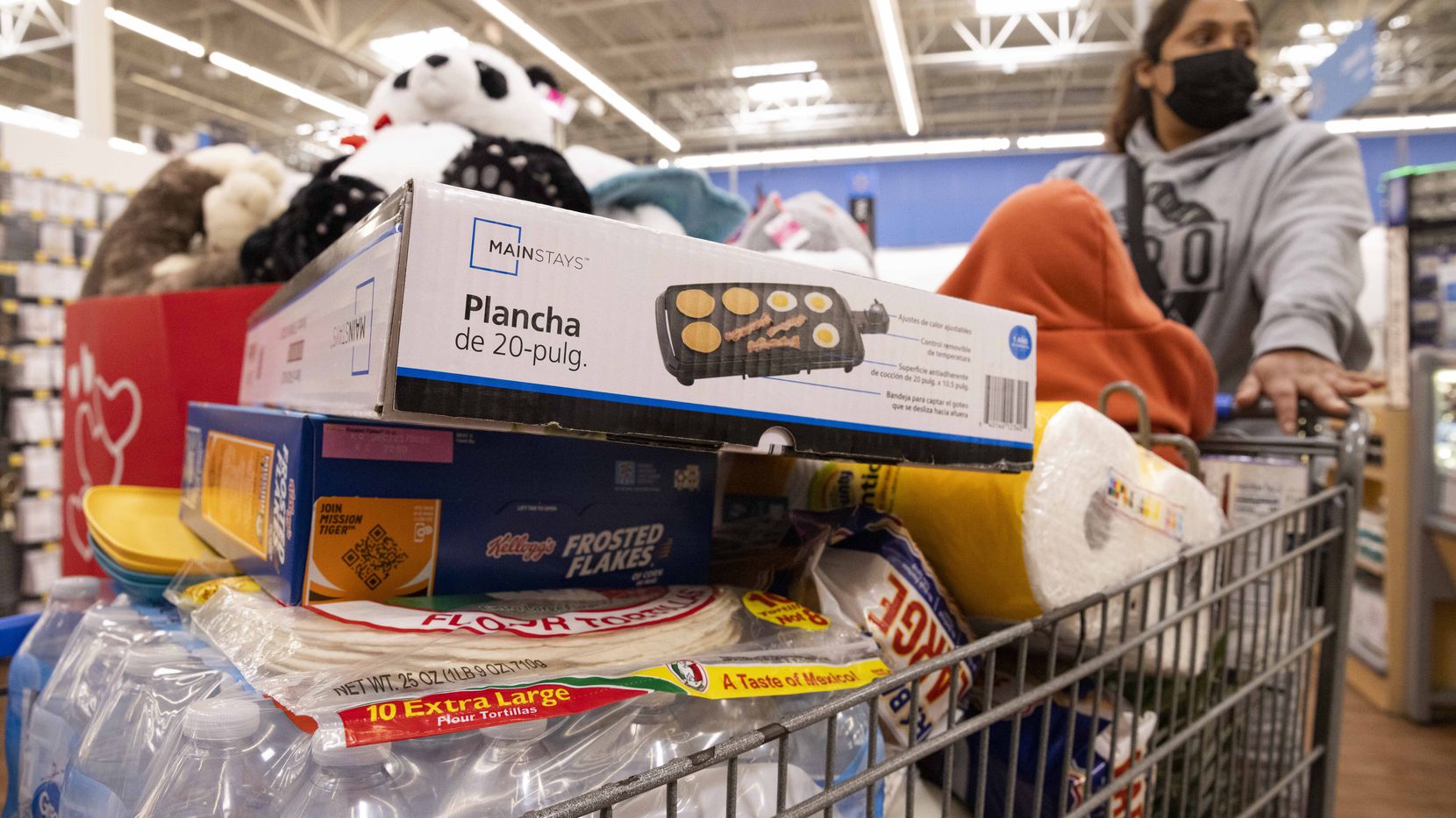 Yezenia Rivera pushes a cart with 9-month-old Jenni Morales as she shops ahead of a winter...