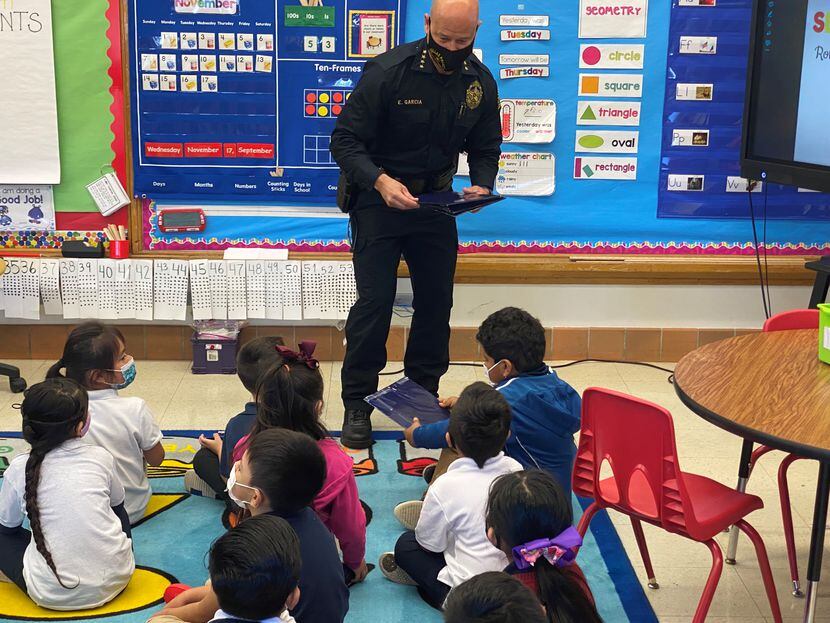 Dallas Police Chief Eddie Garcia handed out books Nov. 29 to students at John Neely Bryan...