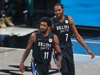 Brooklyn Nets guard Kyrie Irving (11) and Kevin Durant react against the Boston Celtics in...