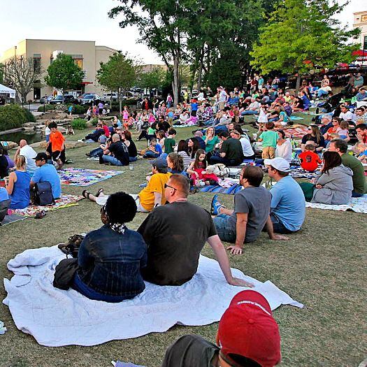 A large crowd gathers on blankets for an outdoor concert at Watters Creek in Allen. 