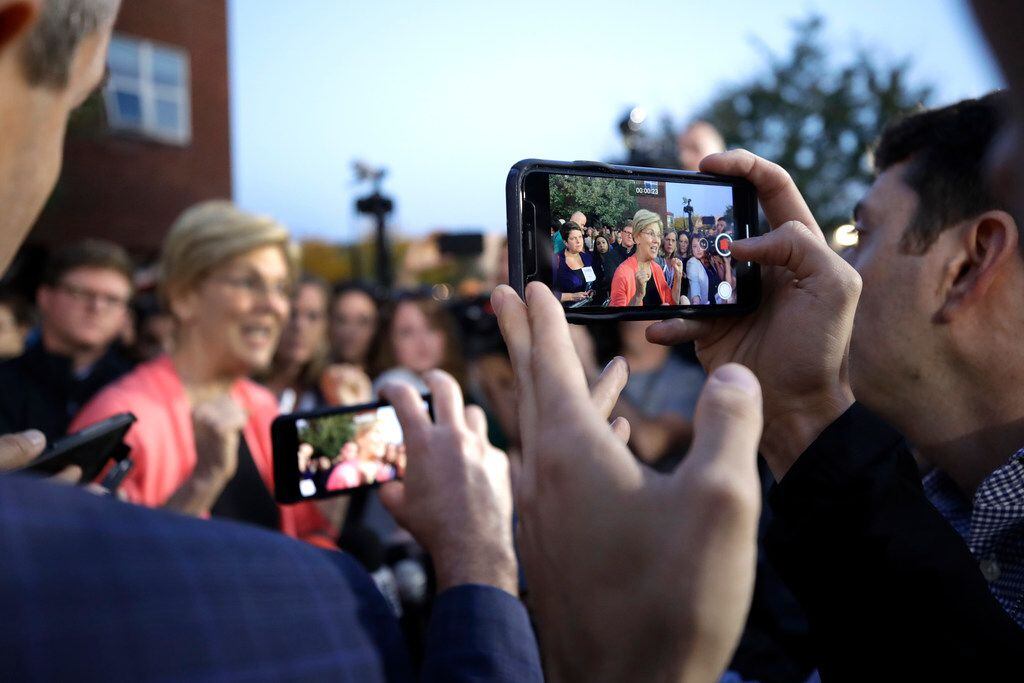 Reporters photograph Democratic presidential candidate Sen. Elizabeth Warren, D-Mass., as...