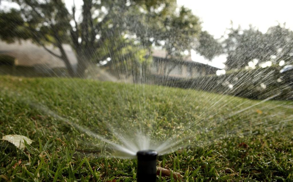 Sprinklers water the lawn in front of a house in the 3700 block of Beverly Dr. in Highland...