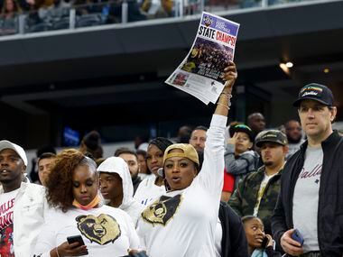 A South Oak Cliff fan raises a newspaper clipping proclaiming the team “state champs” after...