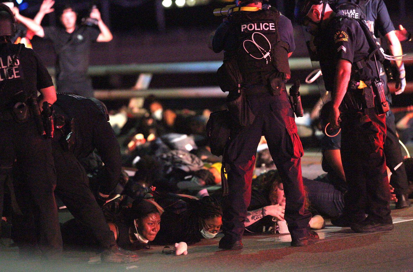 Police have protestors lie on the ground on the Margaret Hunt Hill bridge, while arresting...