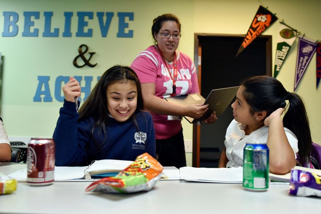 Sixth-graders Mallory Perez (left) and Valerie Perez work on their math homework as mentor...