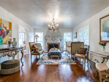 A shot of the formal living room featuring an ornate fireplace, brass-and-crystal...