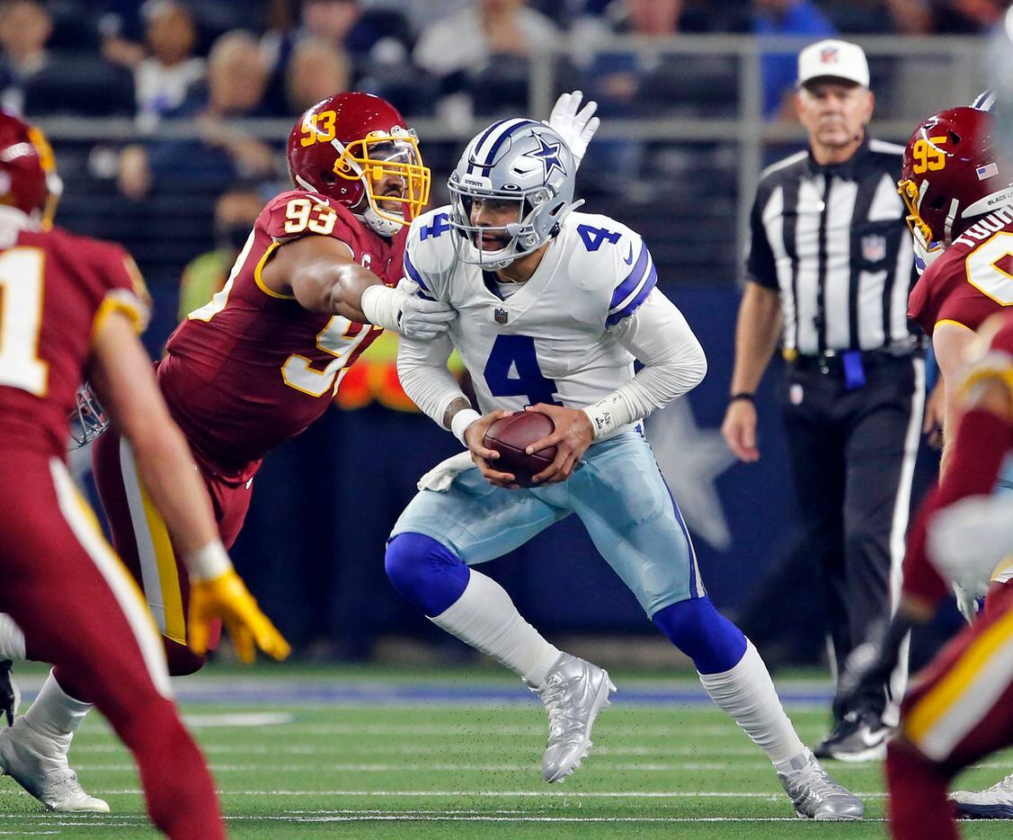 Dallas Cowboys quarterback Dak Prescott (4) tries to elude blitzing Washington Football Team defensive tackle Jonathan Allen (93) during the first half of a NFL football game against/between the Dallas Cowboys and the Washington Football Team at AT&T Stadium in Arlington, TX on Sunday, December 26, 2021.