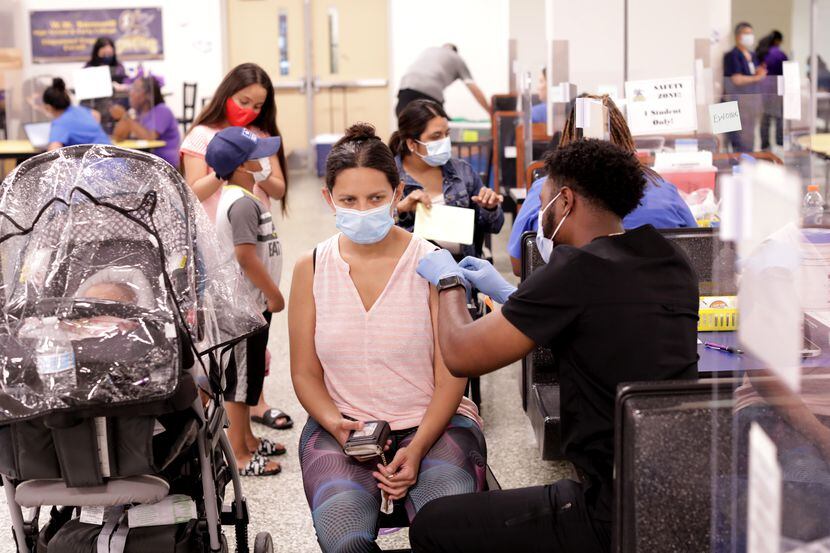 Una Mujer recibe una vacuna contra covid-19 en Samuell High School en Dallas, Texas, el 28...