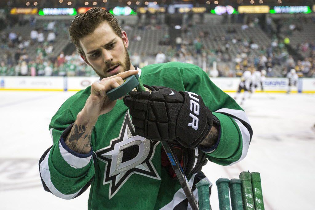 Dallas Stars center Tyler Seguin tapes his stick as the teams warm up before an NHL hockey...