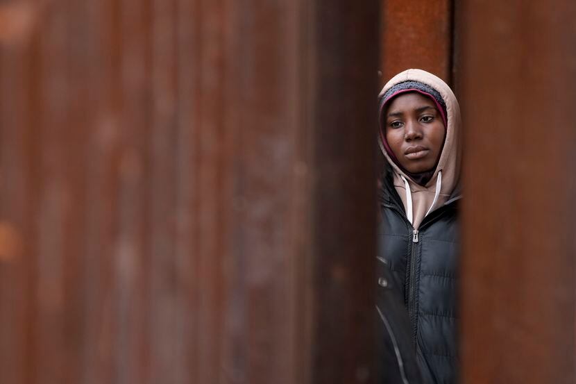 A migrant woman waits between two border walls hoping to apply for asylum, a day after the...