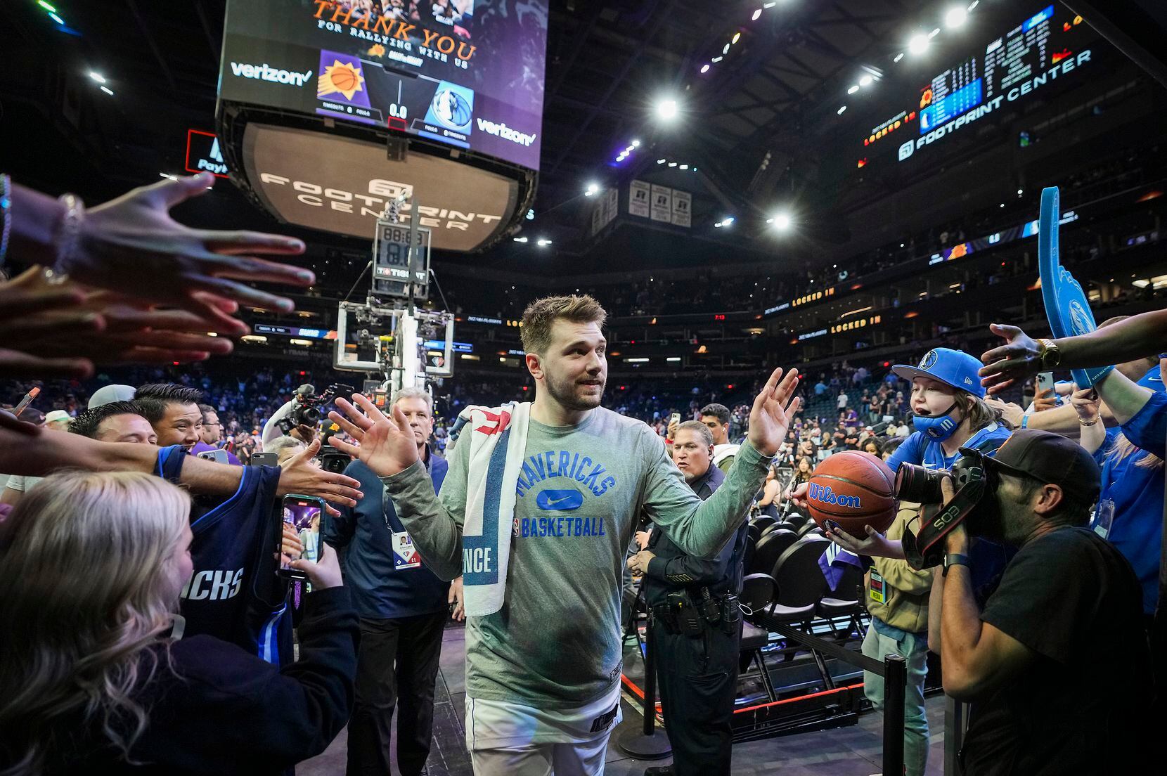 Dallas Mavericks guard Luka Doncic celebrates with fans as he leaves the floor after a...