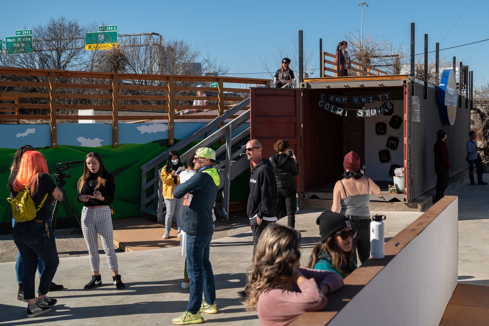 Volunteers and skaters gather outside the new cold storage facility for the Oak Cliff Veggie Project and the 4DWN Project during a soft opening of the storage tank at the 4DWN Skatepark in Dallas on Monday. 