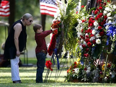 Katrina Ahrens, wife of fallen Dallas police officer Lorne Ahrens, watches her son Magnus...