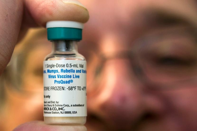 A pediatrician holds a dose of the measles-mumps-rubella (MMR) vaccine 