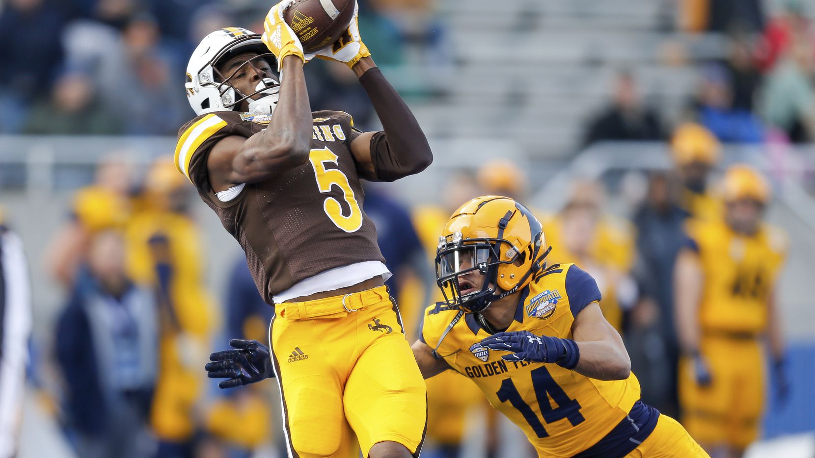 Wyoming wide receiver Isaiah Neyor (5) catches the ball in front of Kent State cornerback...
