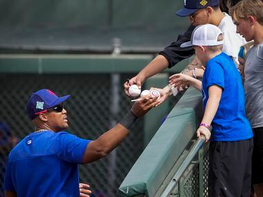 Former Texas Rangers third baseman Adrian Beltre signs autographs for fans during a spring...