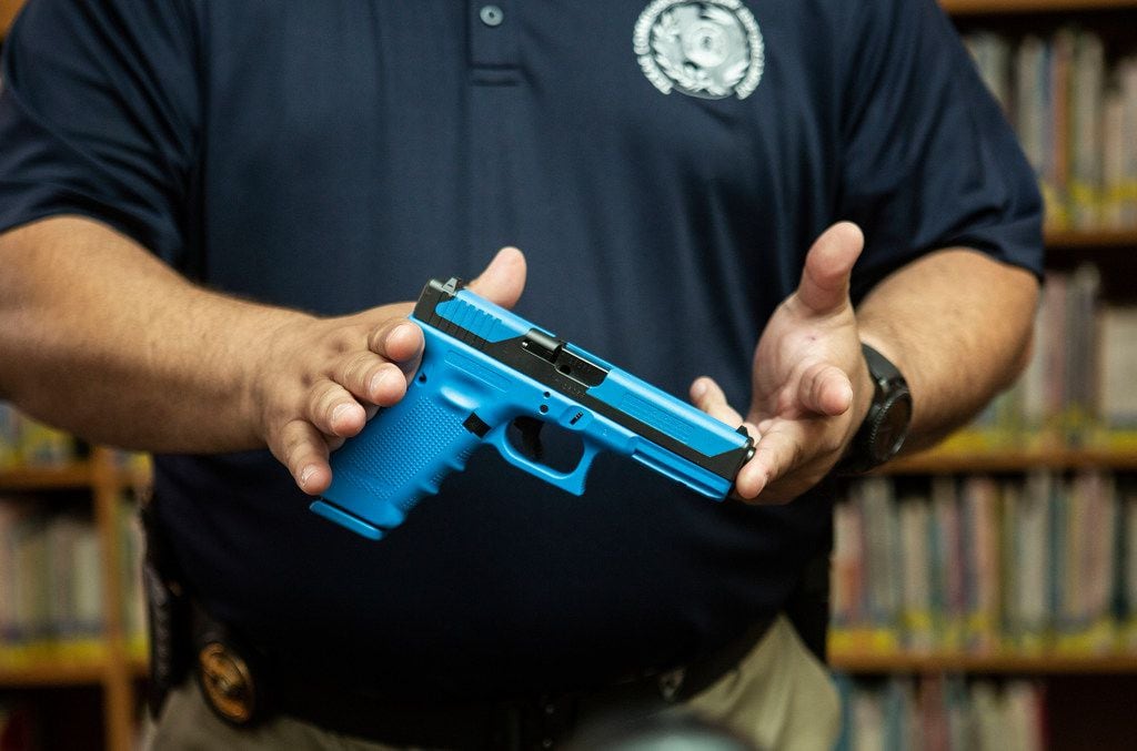 Michael Antu, the Director of Enforcement and Special Services handles a gun that shoots simulated ammunition while talking to the media about what the student school marshals will be using when they perform practice drills during one of the trainings at Windermere Elementary School in Pflugerville, Texas on August 10, 2018. (Thao Nguyen/Special Contributor)

