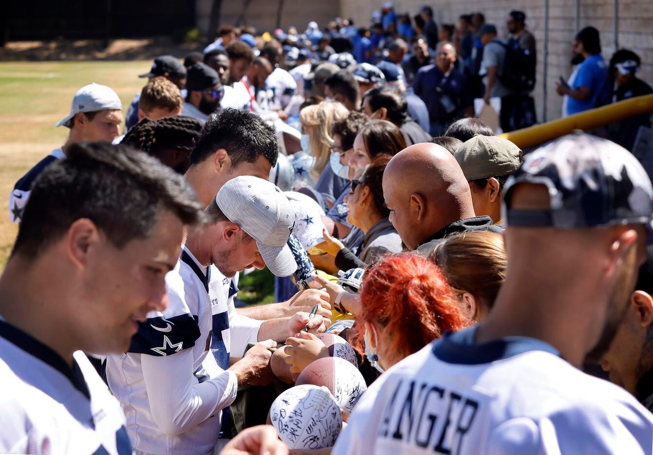 Dallas Cowboys sign autographs for volunteers following their last practice of training camp...