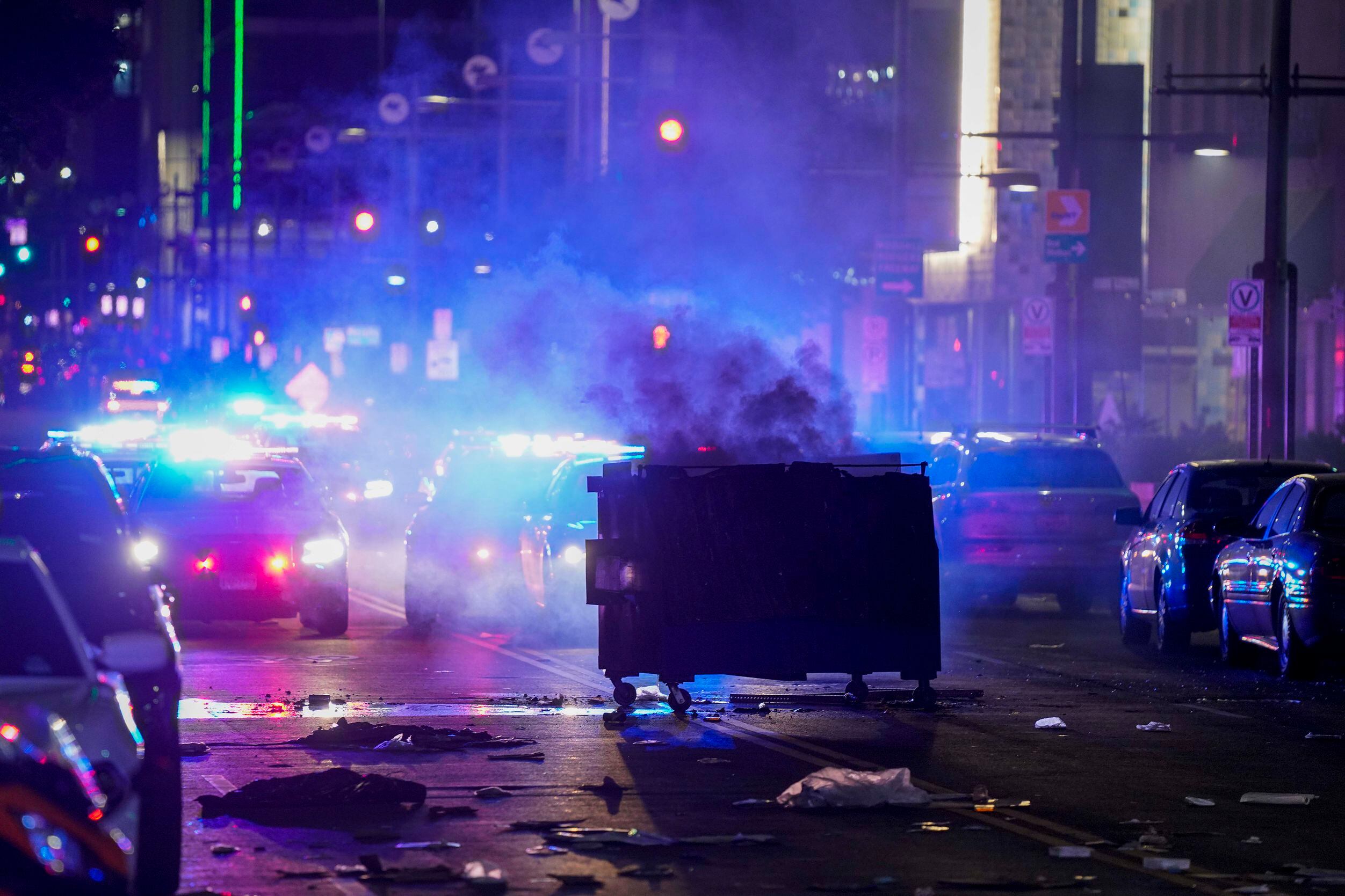 A dumpster smolders as debris covers the middle of Main Street downtown following a protest...